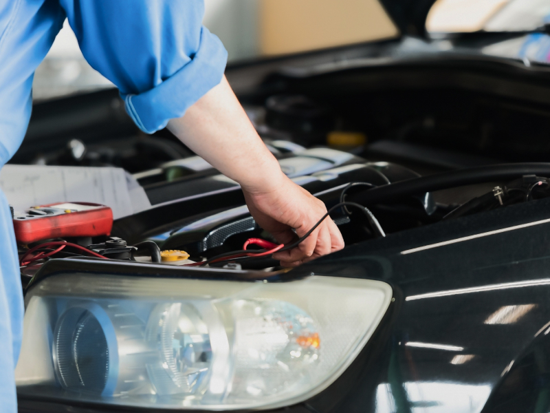 車のボンネットを開けて整備をする写真