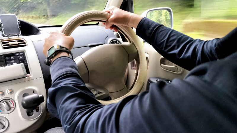 車のハンドルを握る手